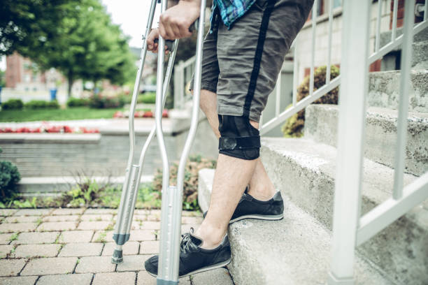 istock Man going down the stairs with crutches 1162624110