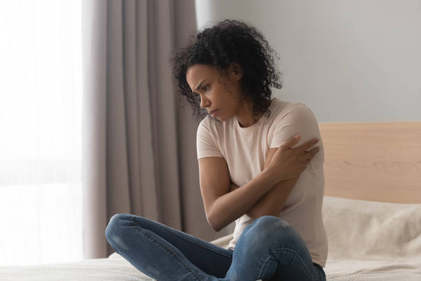 istock Upset depressed african woman feel sad sit alone on bed 1162624113
