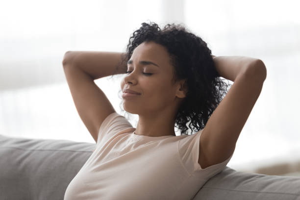 istock Relaxed happy african woman resting lounging sit on sofa 1162624123