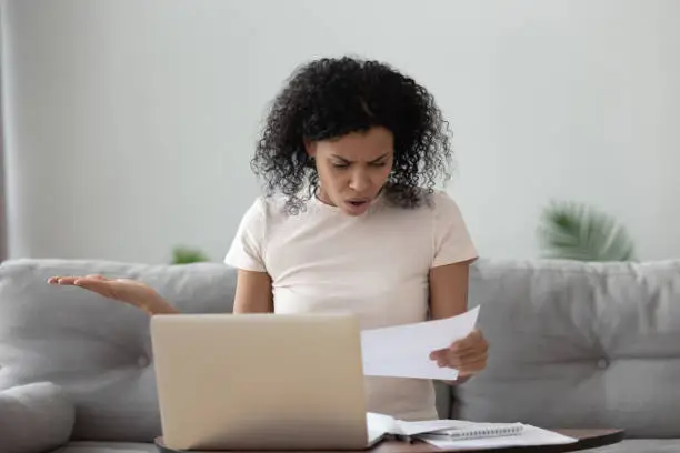 Photo of Angry stressed african girl reading bad news in mail letter