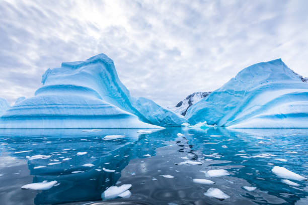 iceberg en antarctique flottant dans la mer, paysage gelé avec des morceaux massifs de glace se reflétant sur la surface de l'eau, péninsule antarctique - sea light water surface water form photos et images de collection