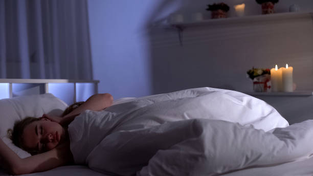 istock Pretty female sleeping deeply in bed at night, resting after hard working day 1162625274