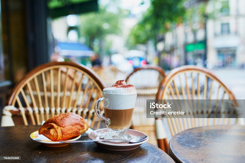 Cup of coffee and fresh pastry in Paris, France Cup of coffee and fresh pastry on the table of traditional French street cafe in Paris, France Paris - France Stock Photo