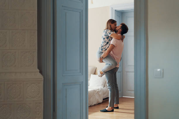istock Profile view of loving young couple hugging while standing in their bedroom 1162625715