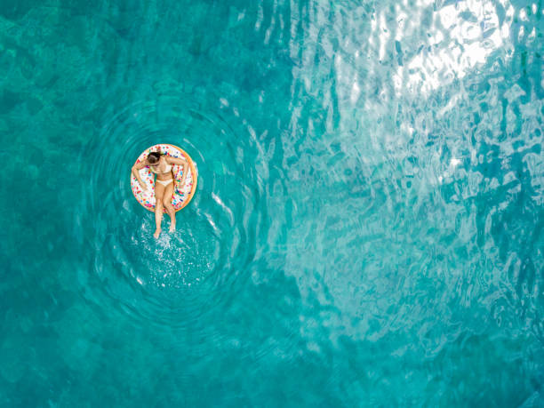 femme appréciant l'été - floating on water women swimming water photos et images de collection