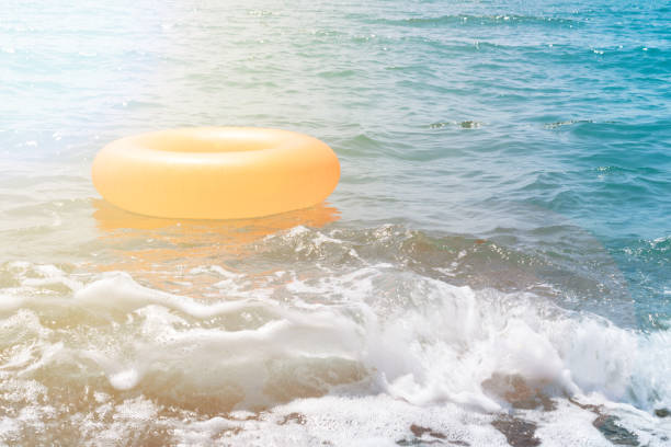 istock orange rubber ring floats in the crystal blue sea in summer 1162631179