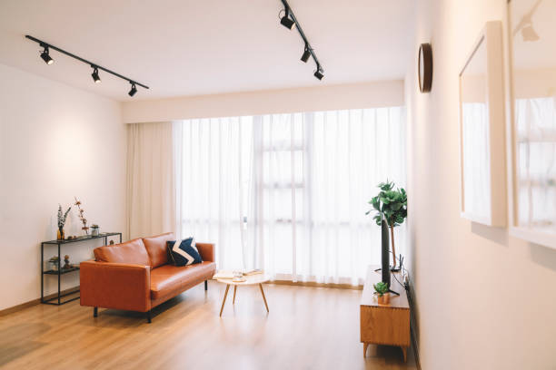 A living room with leather sofa, coffee table, pillow and led TV