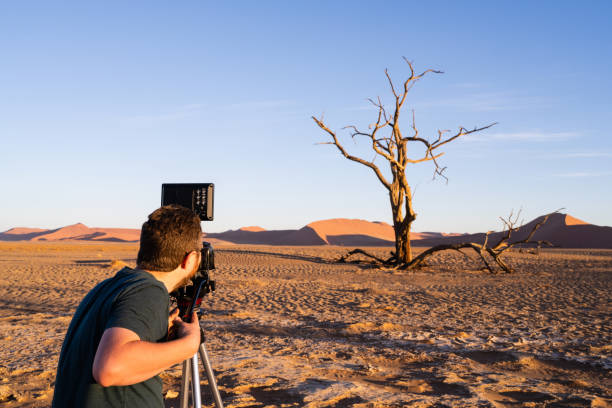istock Man with Camera on Tripod Shooting Nature Video 1162635978