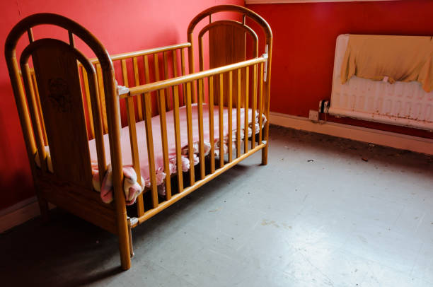 istock Child's cot in a dirty, empty room 1162638463