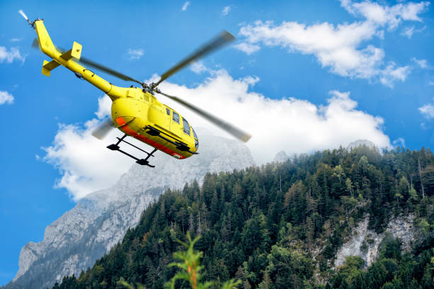An Airbus Helicopter equipped for work flights in mid-flight in front of a snow-covered mountain panorama in the Swiss Alps