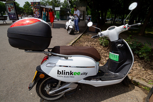 Bucharest, Romania - July 01, 2019: Two blinkee.city mopeds, which can be driven with a B driving license, are parked on a sidewalk in Bucharest. This image is for editorial use only.