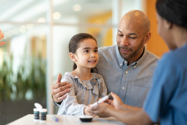 istock Father Holding Young Daughter At A Doctors Appointment 1162646815