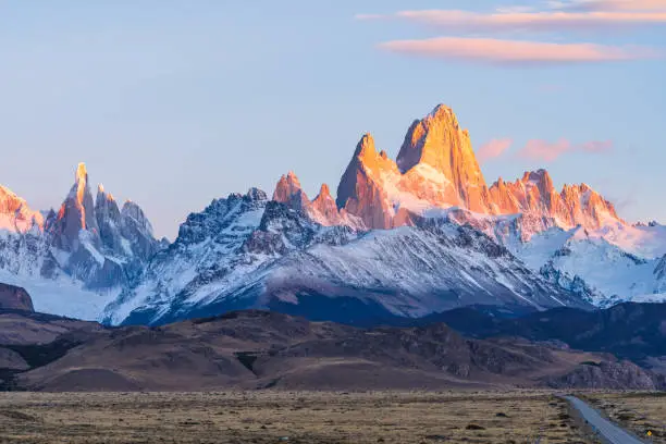 Beautiful dawn golden orange light of sun rise over the Fitz Roy and Cerro Torre peak snow mountain in the morning beside the route 40 road from El Calafate to El Chalten, south Patagonia, Argentina.