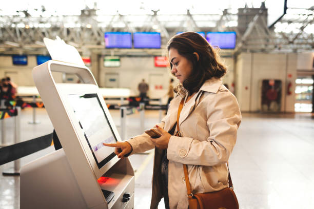Woman checking in at the airport Woman checking in airport check in counter photos stock pictures, royalty-free photos & images