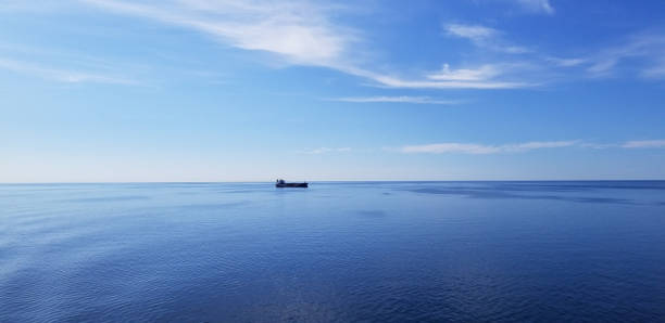 istock Bright blue seascape and cargo ship 1162652551
