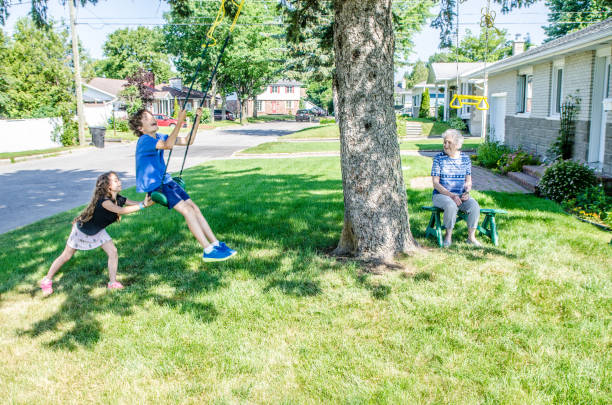istock Girl pushing brother on swing 1162654659