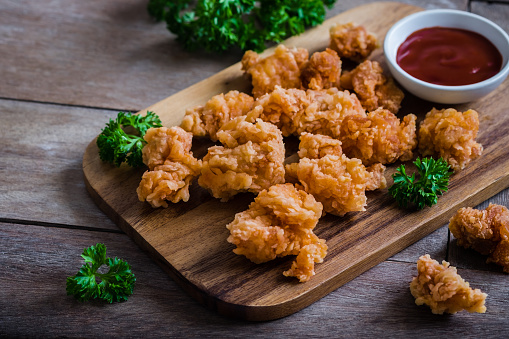 Crispy popcorn chicken on wooden board and dipping sauce