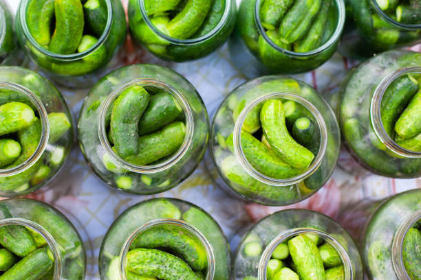 el proceso de enllanado pepinillos encurtidos para el invierno, encurtidos pepinos en frascos de vidrio - preserves pickle jar relish fotografías e imágenes de stock