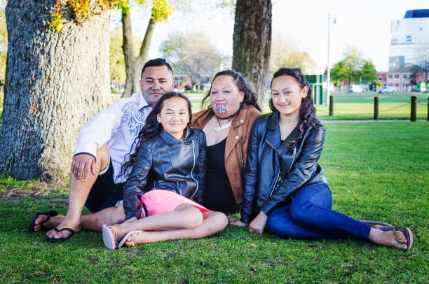 Portrait of a young Maori family taken outdoors in a park setting stock photo