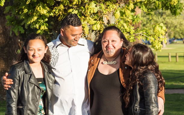Portrait of a young Maori family taken outdoors in a park setting stock photo