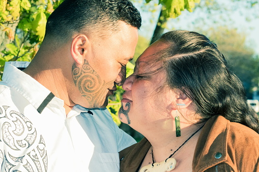 Portrait of an attractive Maori couple connected in a traditional hongi