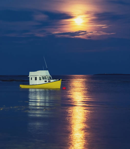 Bright yellow fishing boat in the light of the Full Moon.