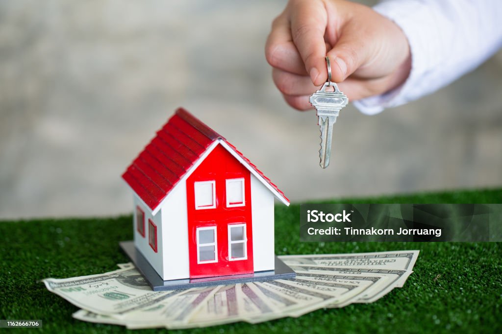 Your new house, real estate agent holding house key to his client after signing contract agreement in office,concept for real estate, renting property Agreement Stock Photo