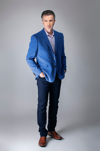 Middle-aged Caucasian businessman looking posh wearing modern fall collection style blue jacket.  Depicts confident and mature stylish fashion.  Shot in studio for catalog look.