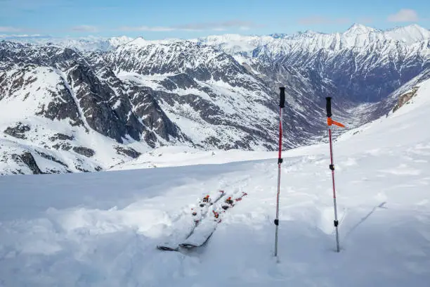 After a long hike, skis and poles sit near the top, overlooking a vast glacial valley below Snowbird Glacier in the Hatcher Pass area of the Talkeetna Mountains, Alaska.