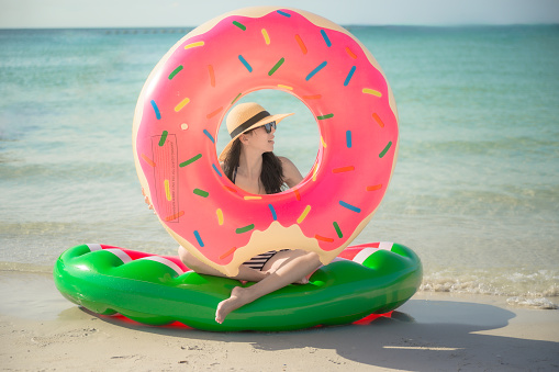 young woman enjoy swimming on the sea beach by fool around with floating inflatable swimming tube on  the sea beach, summer time and long weekend vacation hapiness