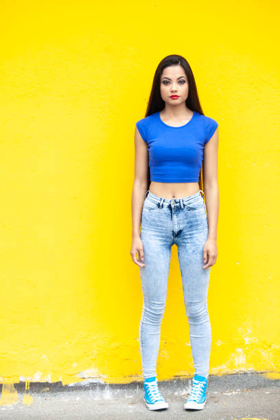 istock Woman in front of yellow  wall background 1162687461