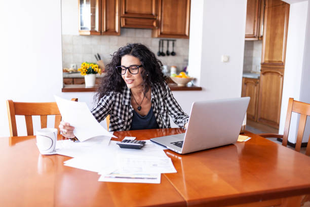 istock Cheerful woman using credit card at home 1162688679