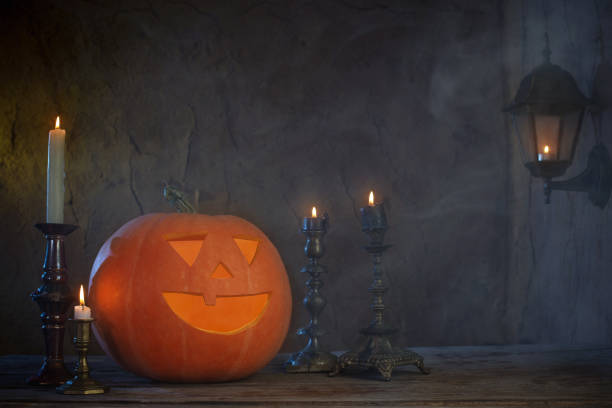 istock Halloween pumpkins on wooden table on dark background 1162690267