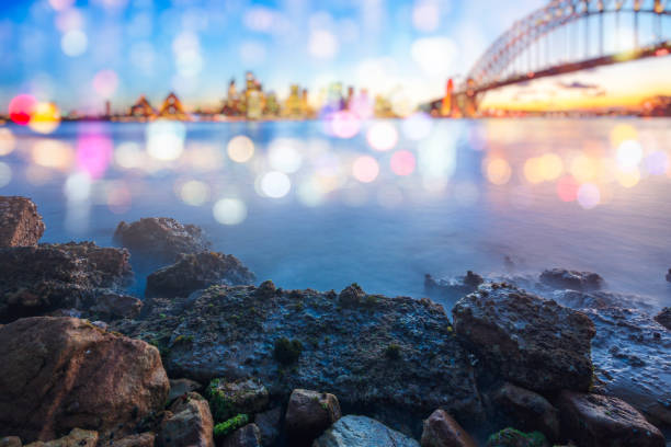 сумерки вид на гавань сиднея и сидней гавани мост против неба, австралия - the rocks sydney harbor sydney australia new south wales стоковые фото и изображения