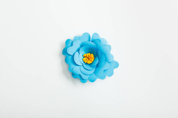 top view of blue paper flower on grey background