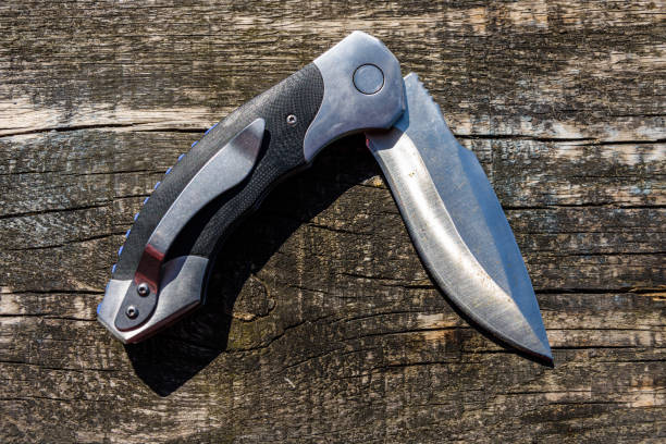 istock Folding knife on the rustic wooden background 1162695631