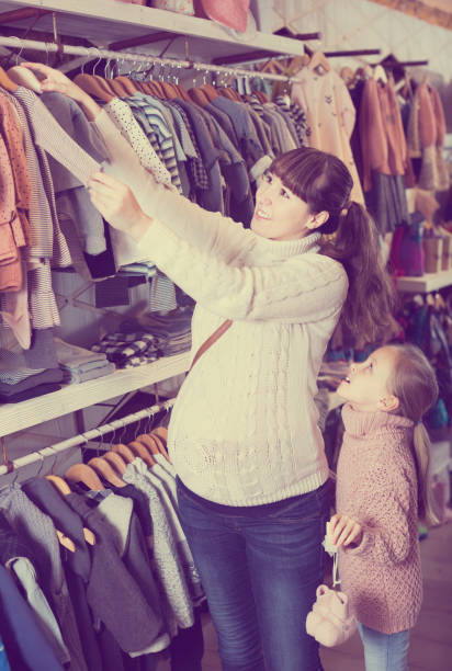 istock Daughter helps mom choose clothes for newborns 1162698710