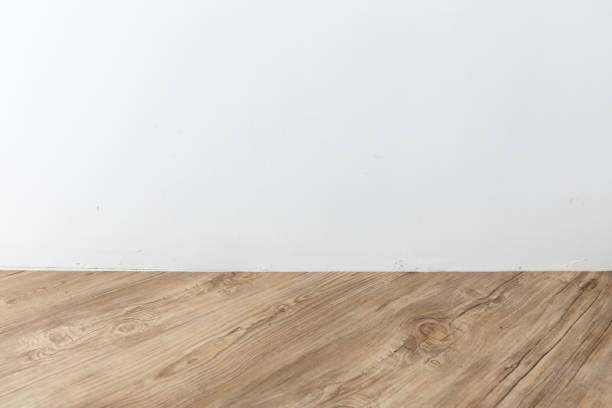istock perspective view of empty interior room with white cement wall and brown wooden herringbone floor. 1162700397