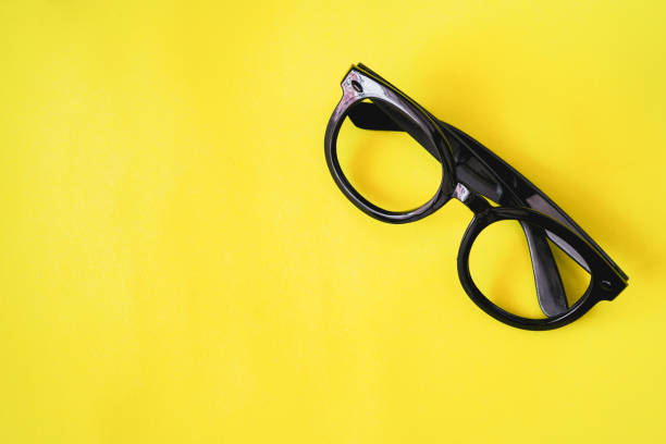 istock black eyeglasses isolated on yellow background, top view 1162700886