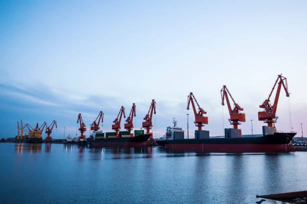 istock Gantry crane and cargo ship in the evening, Shipping and logistic concept 1162704761