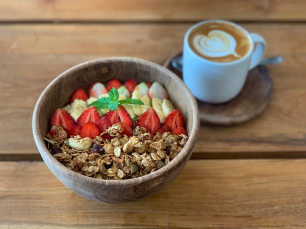 istock Breakfast muesli bowl with fruits and cappuccino cap 1162706230