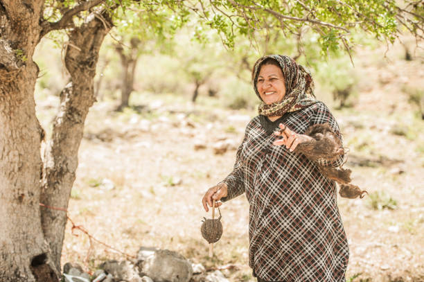istock Senior Nomad Woman Spinning Wool for Making Carpet, Iran 1162709957