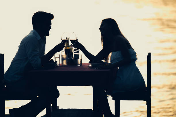 istock Young romantic couple toasting during dinner on tropical vacation 1162710312