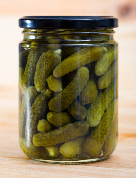 istock Glass jar with pickled cucumbers on wooden background 1162711279