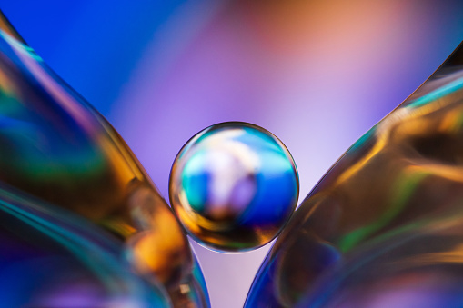 Small glass ball in abstract macro composition. Photo of glass molds