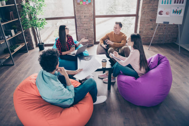 istock Company of nice attractive smart clever professional experts it specialists managers creating plan analysis data marketing sitting on bag chair at industrial loft interior workplace workstation 1162712277