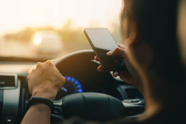 istock Man using cell phone while driving concept for danger of text message and being distracted , using smart phone mobile phone in car 1162712918