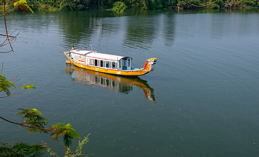 Hue, Vietnam - April 9th, 2019: Cruise lonely boat at Perfume river. This is eco-tourism means peaceful waterways in the imperial city in Hue, Vietnam