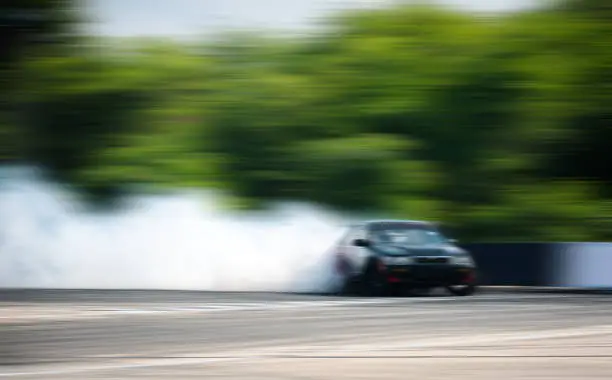 Car drifting, Blurred of image diffusion race drift car with lots of smoke from burning tires on speed track