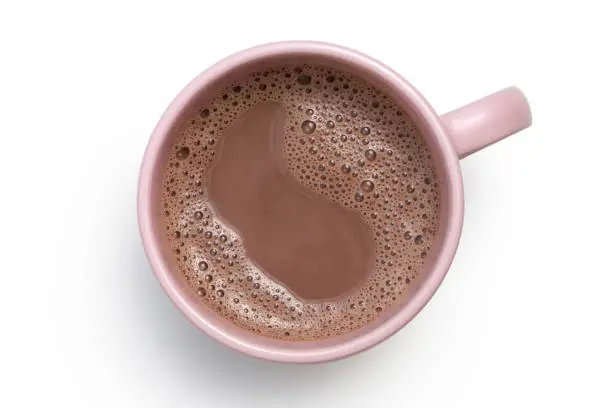 Hot chocolate in a pink ceramic mug isolated on white from above.